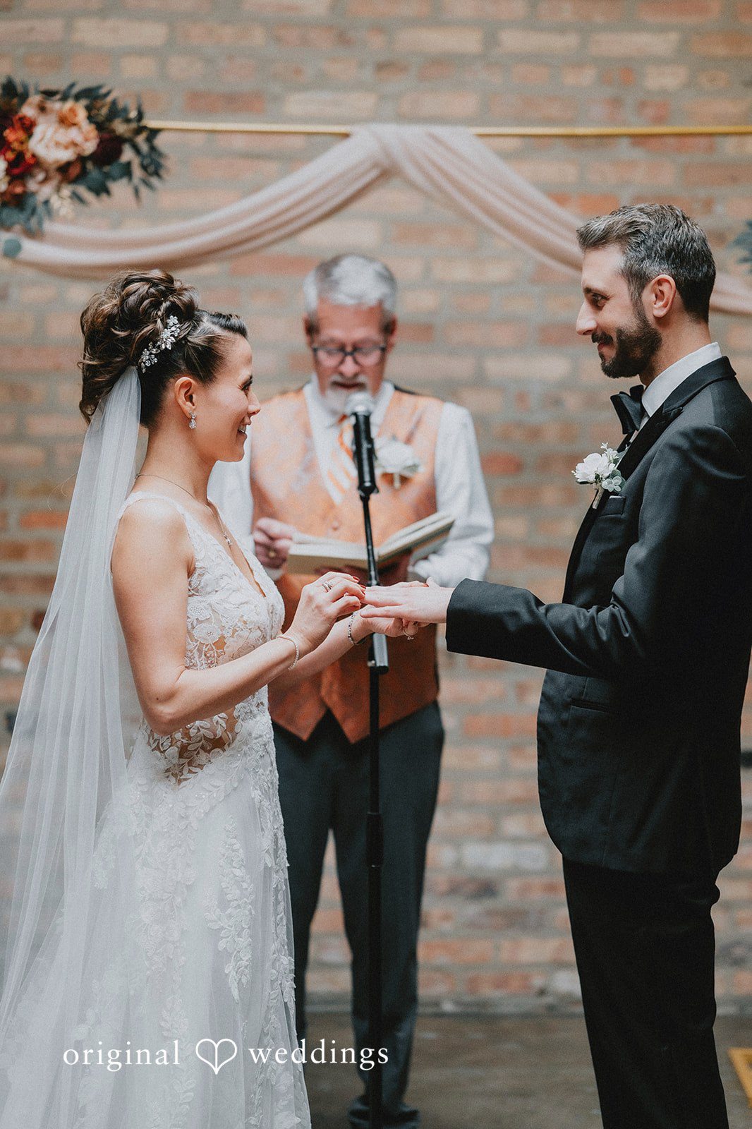The bride puts a ring on the groom's finger