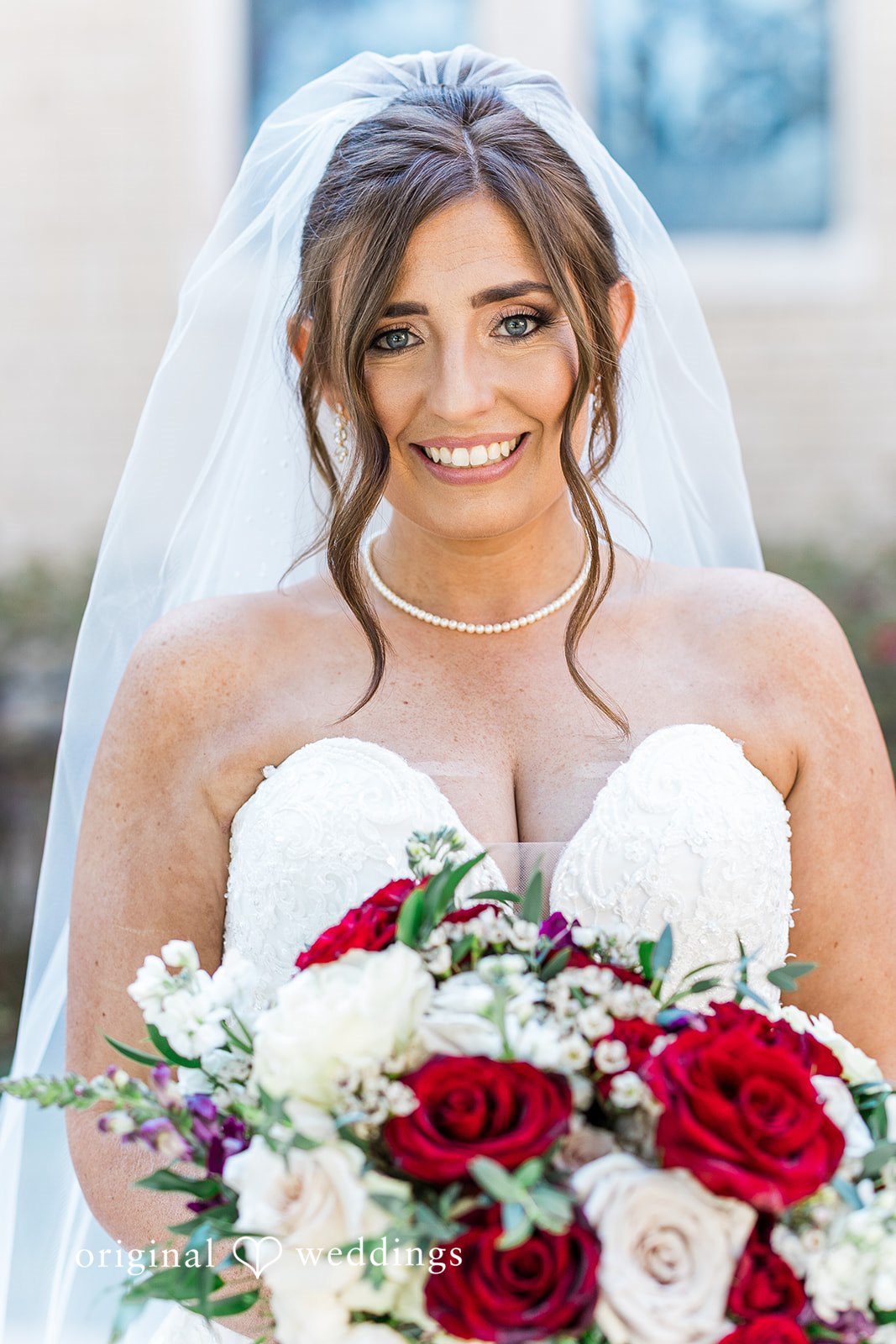 Bride holding bouquet and smiling at The Carlisle Room