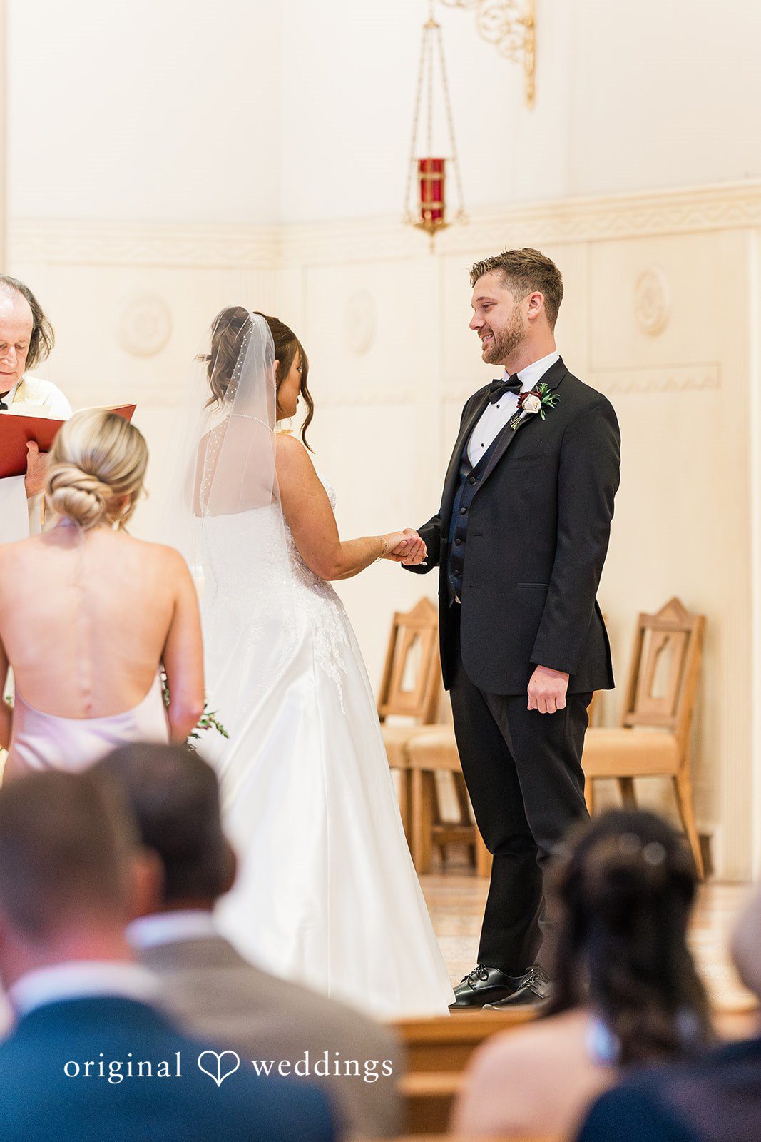 Groom holding bride’s hand and looking at her at The Carlisle Room