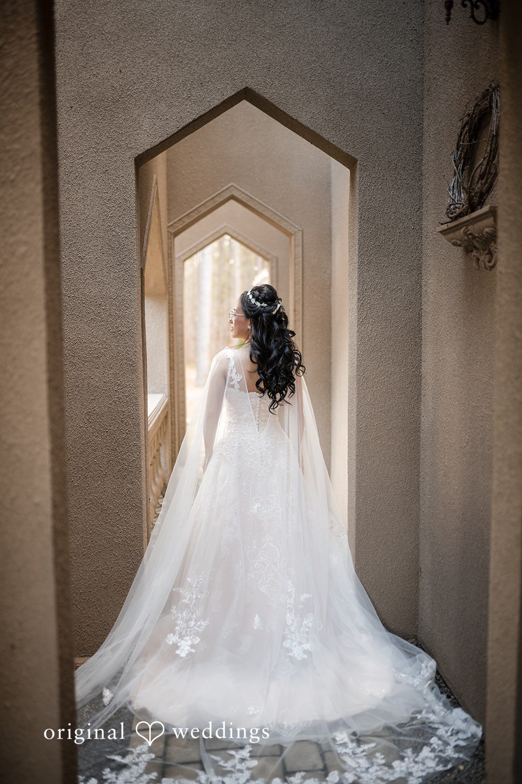 Nghi + Christopher Stylish bridal back pose featuring a long wedding veil at The Castle at Wildwood Gardens