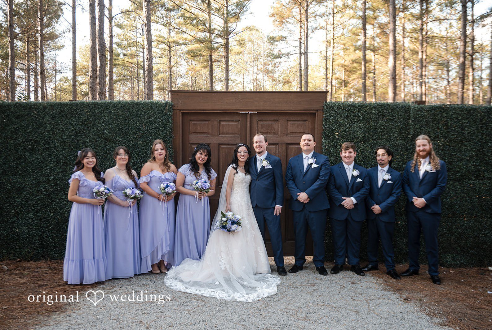 Atlanta Wedding Photographers capturing a joyful group portrait of the couple with bridesmaids and groomsmen at The Castle at Wildwood Gardens by Original Weddings