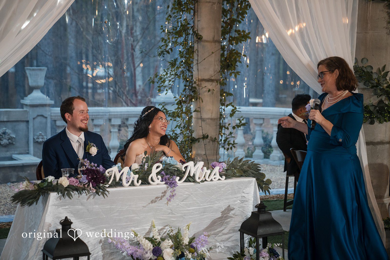 Nghi + Christopher Atlanta Wedding Photographers capturing the couple seated at their beautifully decorated reception table at The Castle at Wildwood Gardens by Original Weddings