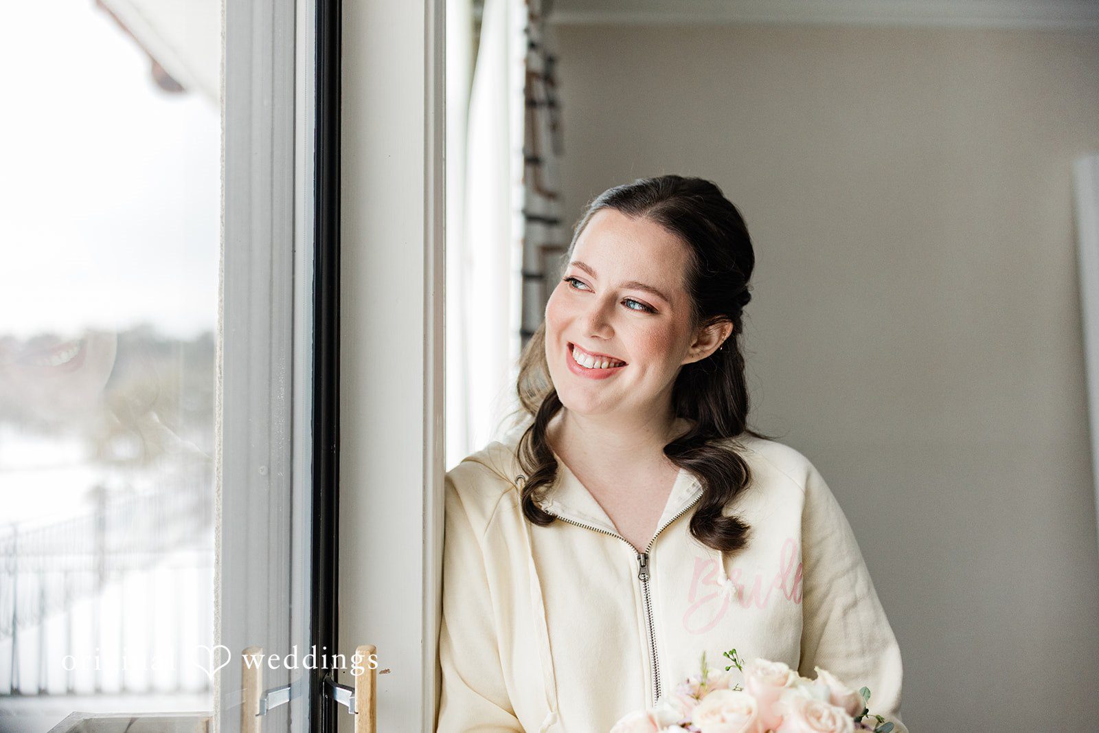 Smiling bride holding bouquet while getting ready on wedding day