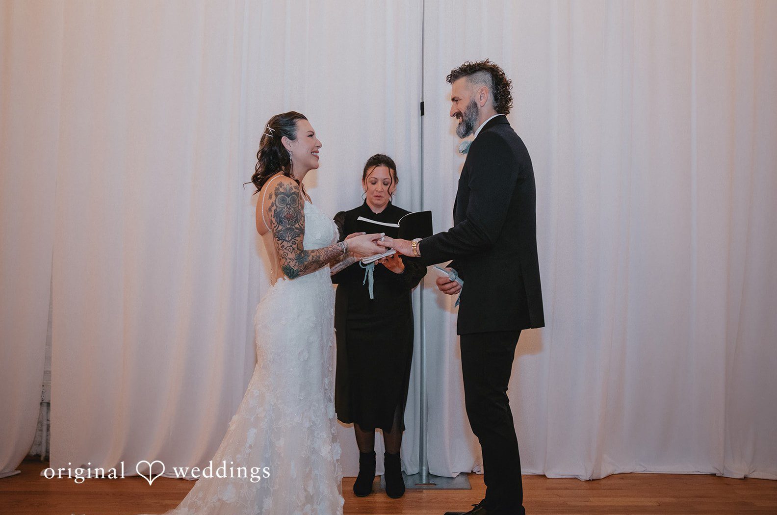 Raleigh wedding photographers capture a beautiful indoor ceremony moment at The Durham Exchange as the couple stands together during their vows.
