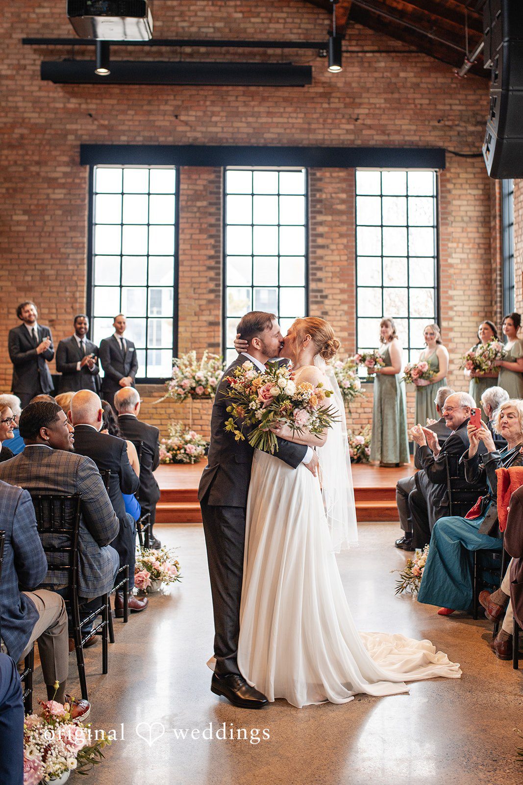 Elegant bride and groom kiss moment at The Essence Event Center
