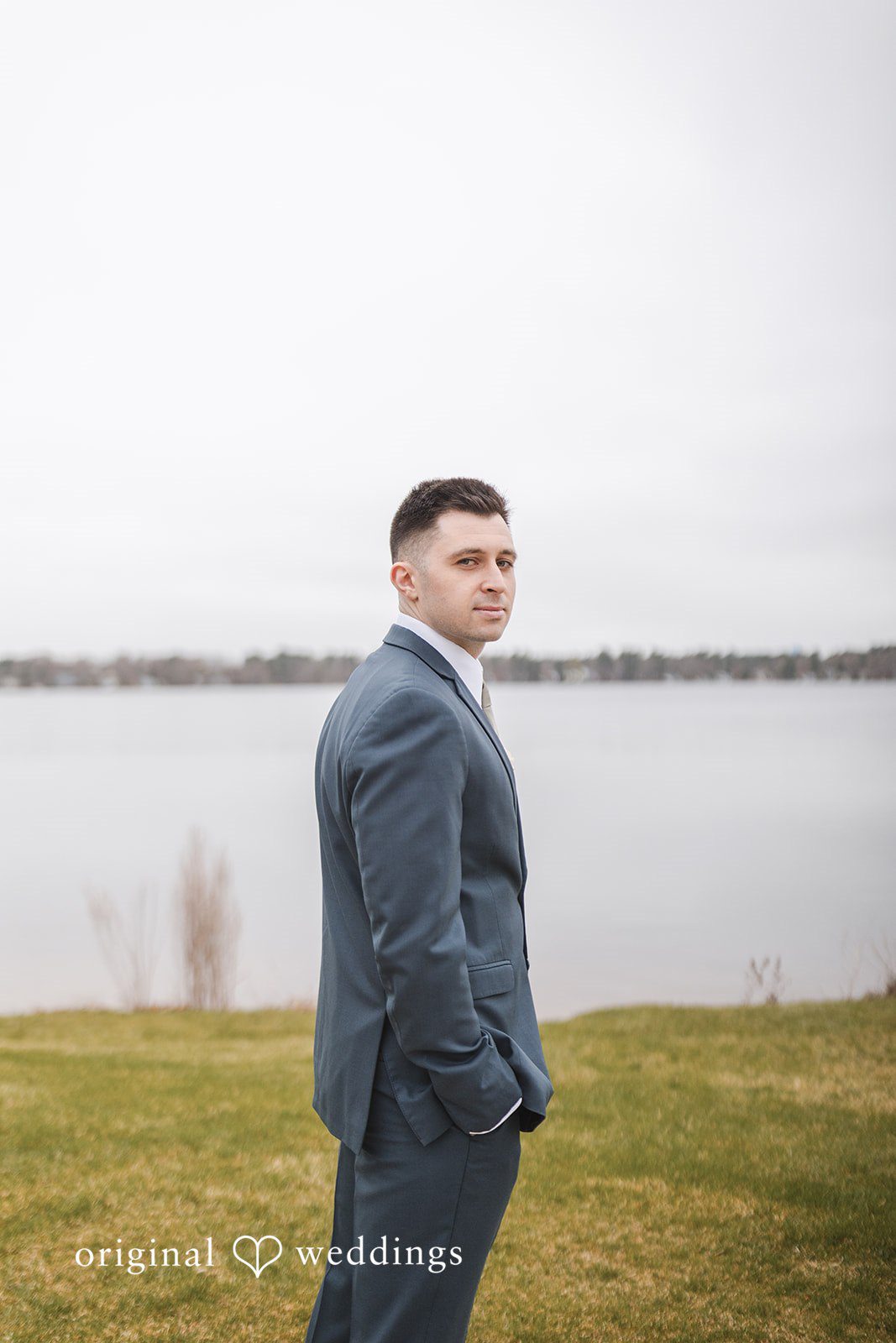 A stunning portrait of the groom by the lakeside