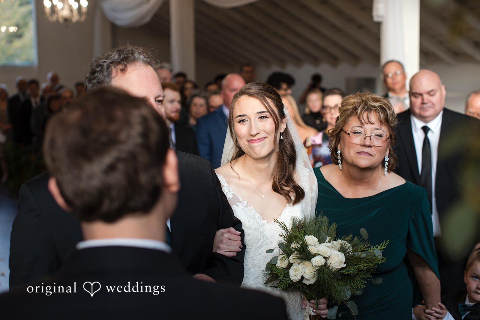 Adam + McKenzie Indoor ceremony aisle with guests and greenery decor captured by St. Louis wedding photographers