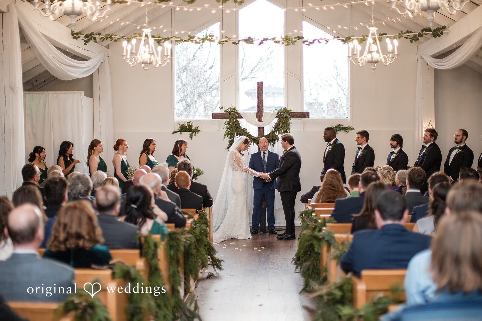 Adam + McKenzie Wide view of ceremony setup with floral arrangements and classic architecture