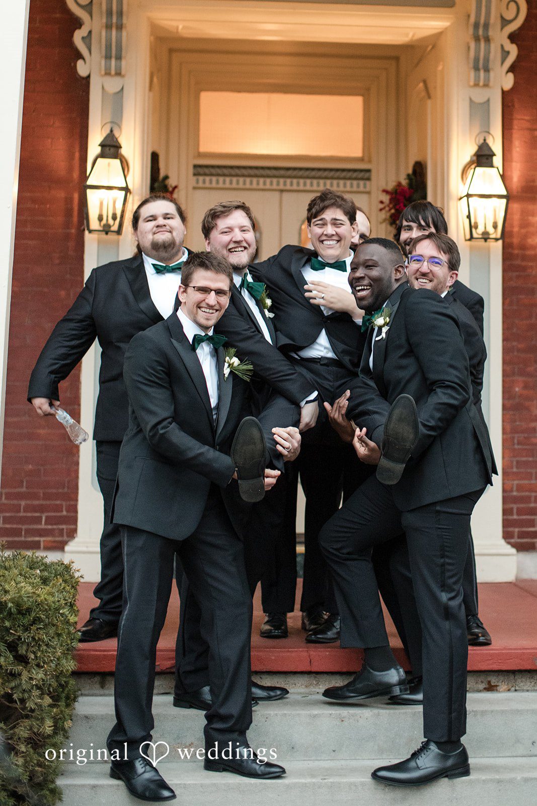 Adam + McKenzie Fun groomsmen group pose with playful energy outside The Larimore