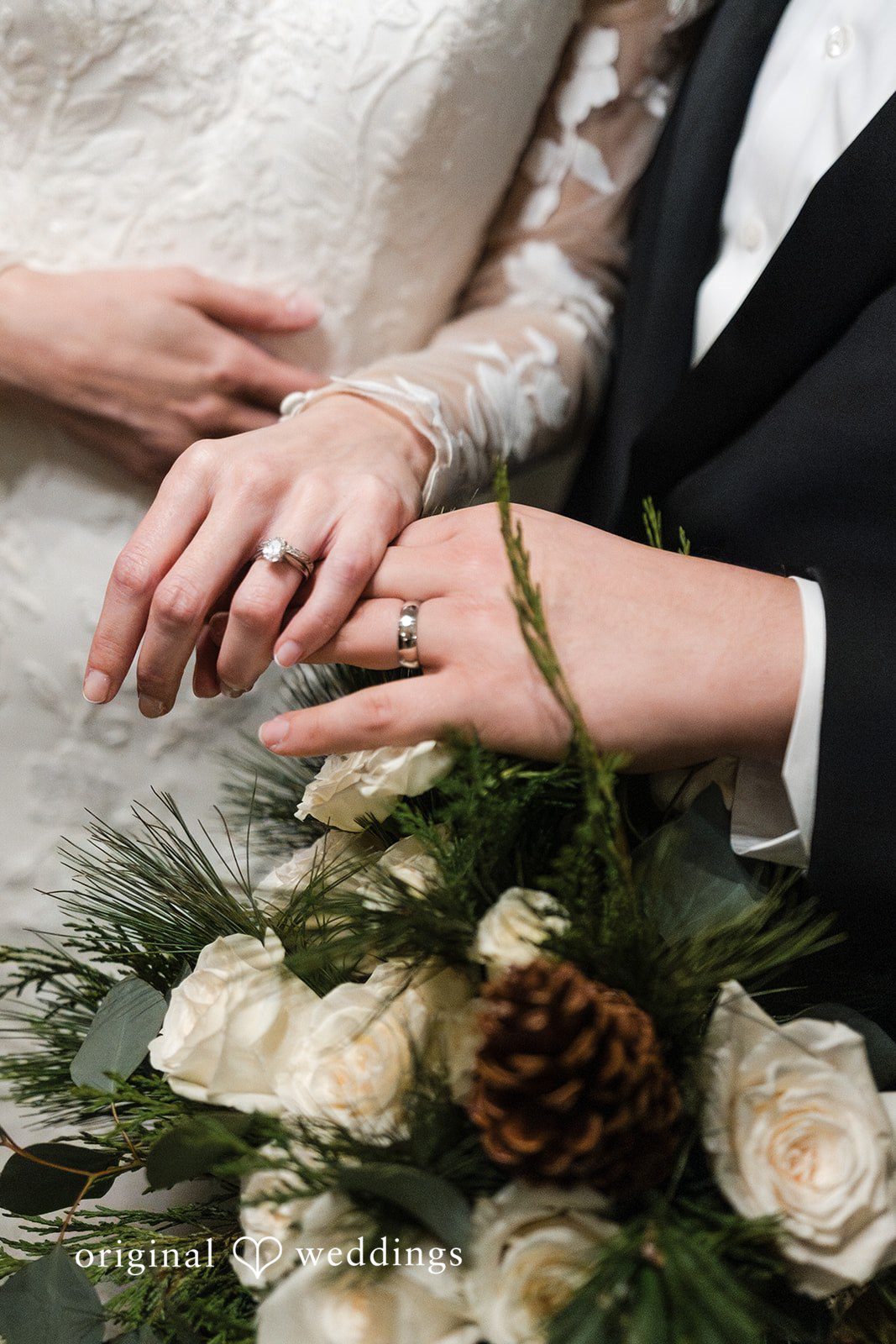 Adam + McKenzie Close up of couple holding hands with wedding rings and bouquet in natural light