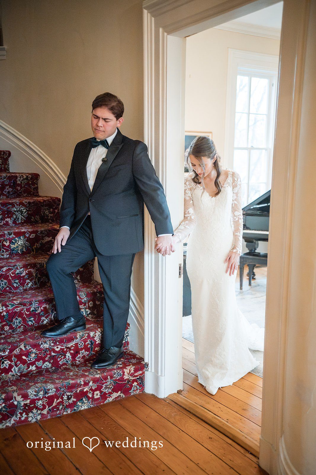 Adam + McKenzie Couple walking down staircase hand in hand captured by St. Louis wedding photographers