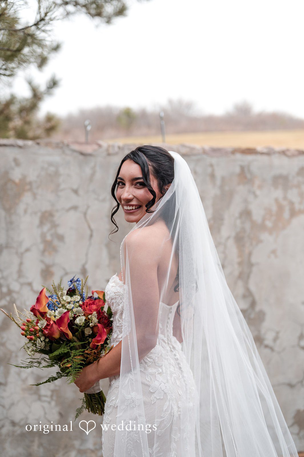 Elegant bride smiling with bouquet at The Oaks