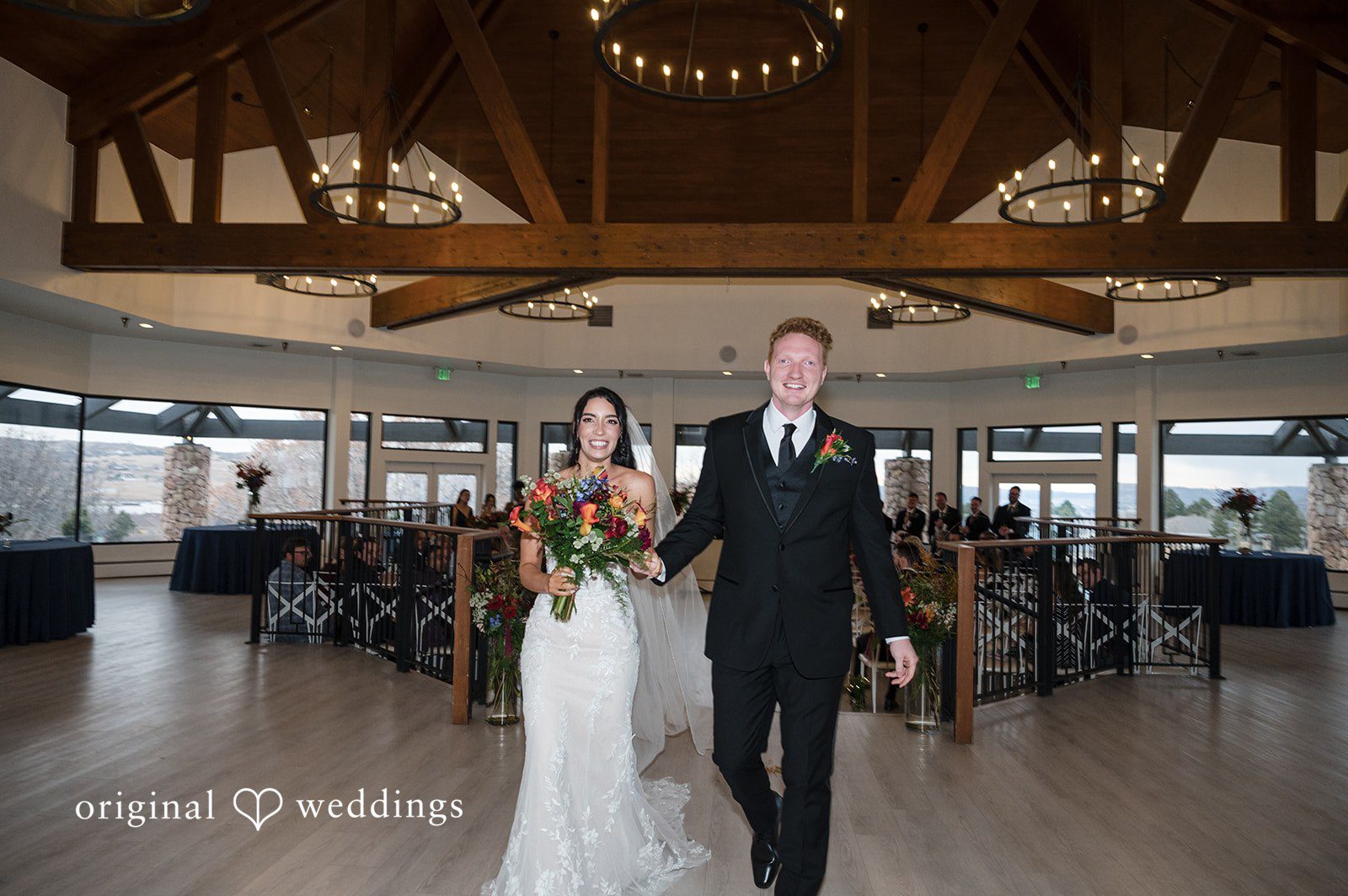 Denver Wedding Photographers capturing couple walking out of ceremony smiling at The Oaks by Original Weddings