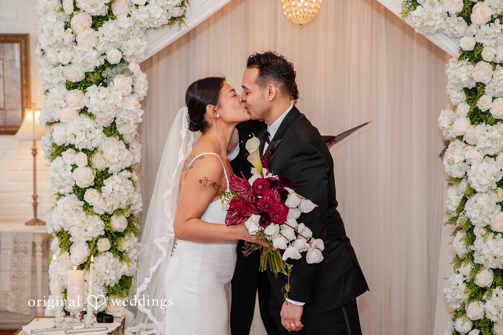 Amanda + Emmanuel Bride and groom sharing a kiss during their wedding ceremony.
