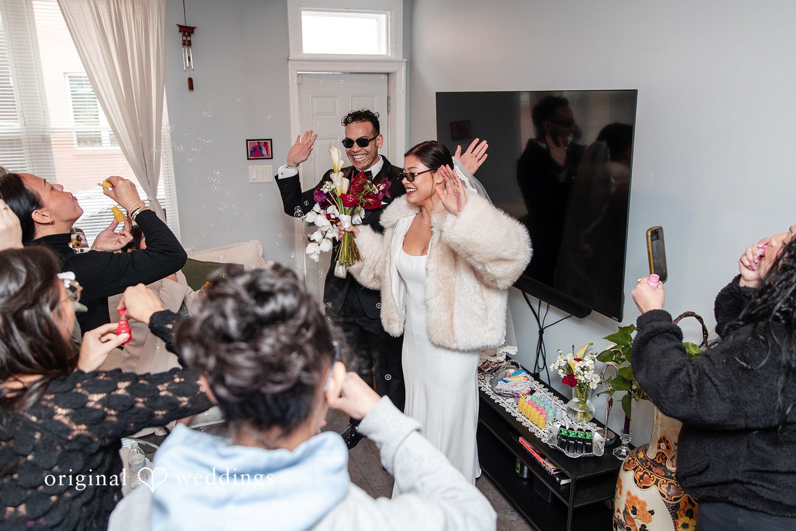 Amanda + Emmanuel Bride and groom celebrating with guests in a room.