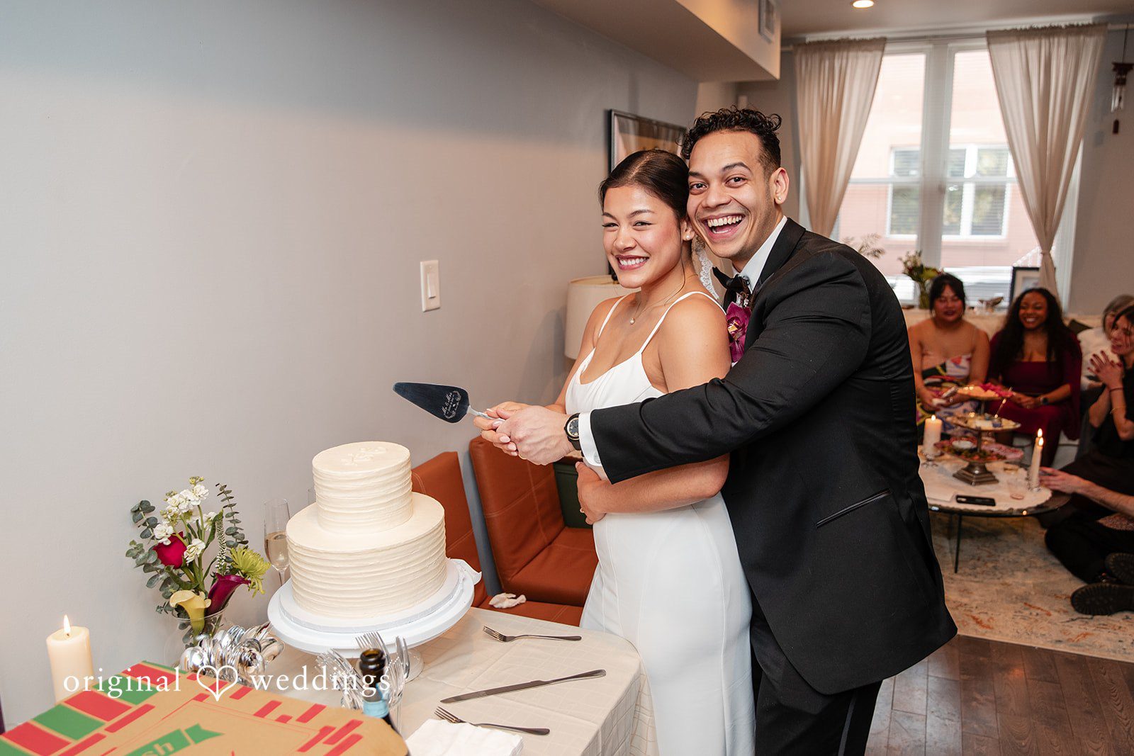 Amanda + Emmanuel Bride and groom smiling together as they prepare to cut their cake.