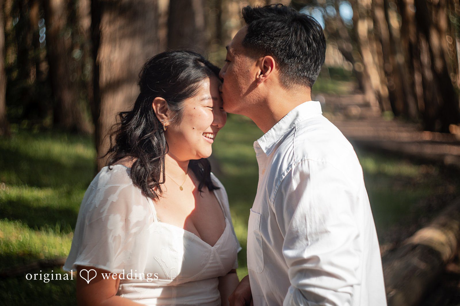 San Francisco Engagement Photography by Original Weddings capturing a couple sharing a sweet moment with a kiss on the forehead during their engagement session at The Presidio.
