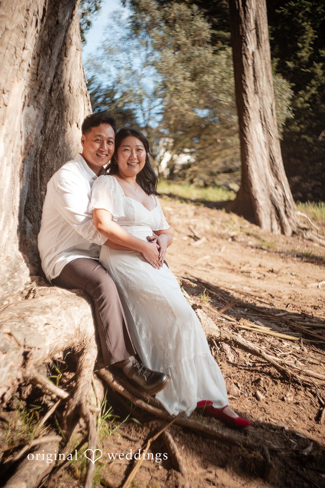 Couple sharing a joyful moment while sitting together on a tree trunk