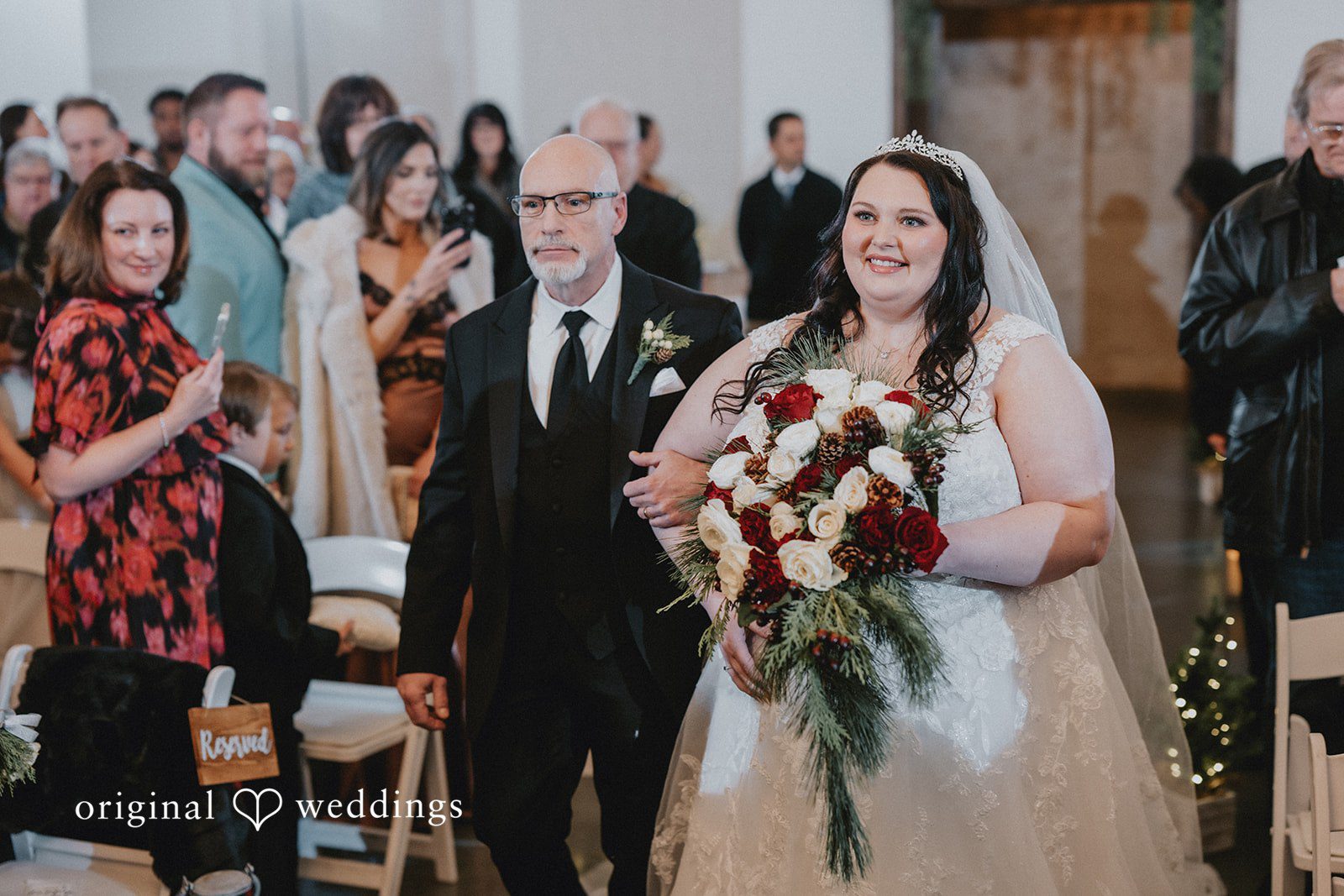The bride's father escorts the bride down the aisle
