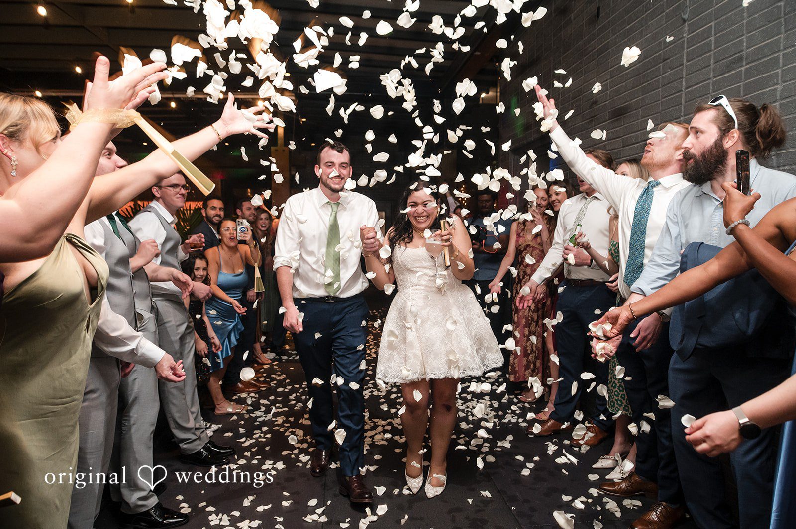 Paola + Jeremy Bride and groom exit surrounded by celebration confetti