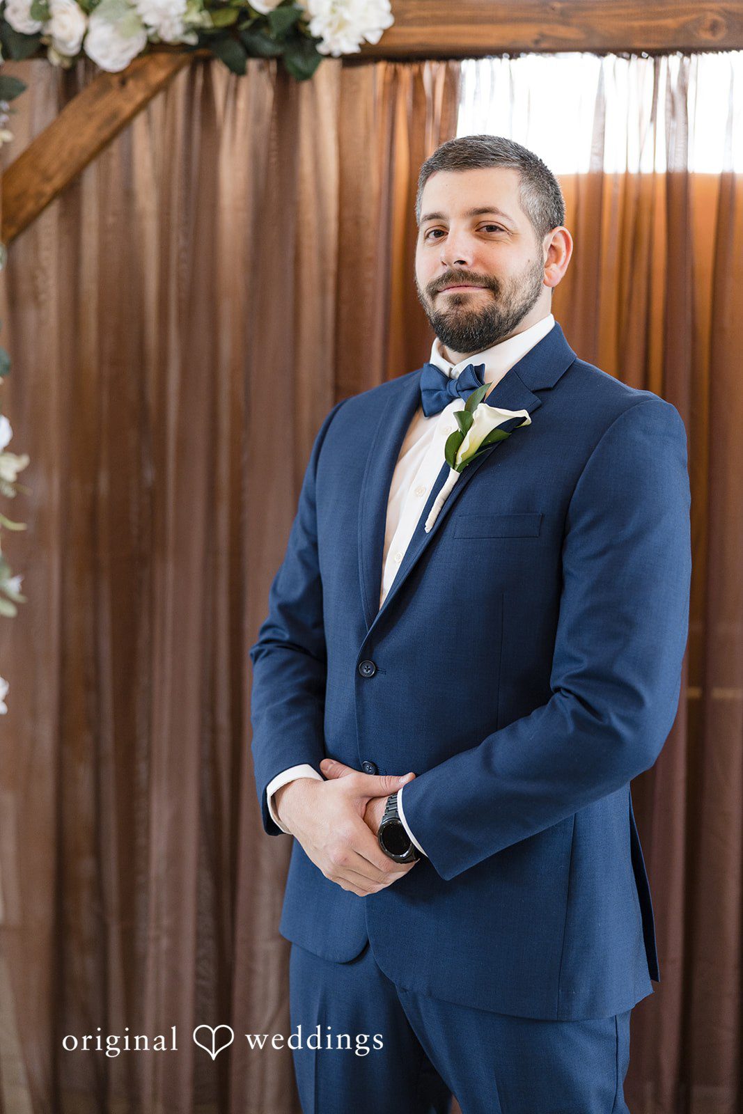 Alia + Lance Groom posing in a navy blue suit and matching bow tie.