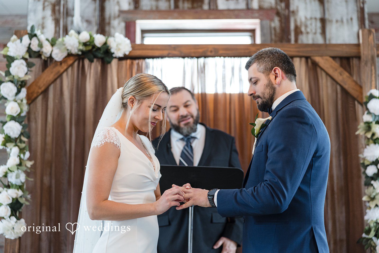 Alia + Lance Bride placing a wedding ring on the groom's finger.