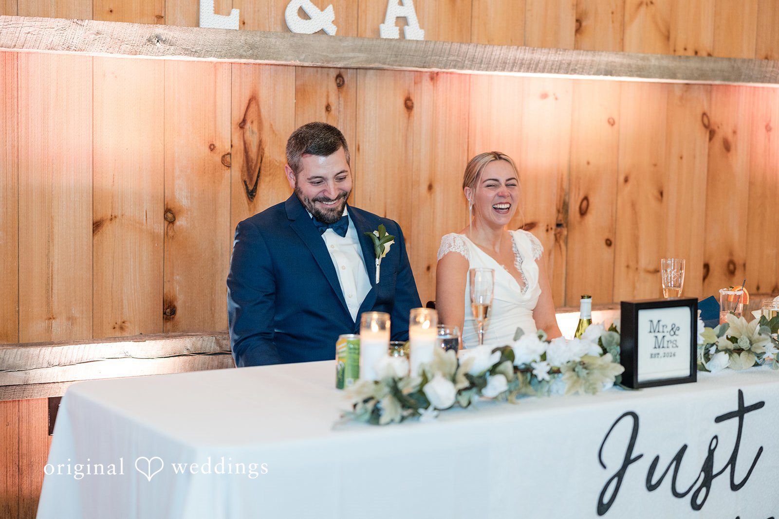 Alia + Lance Bride and groom sitting at their decorated reception head table.