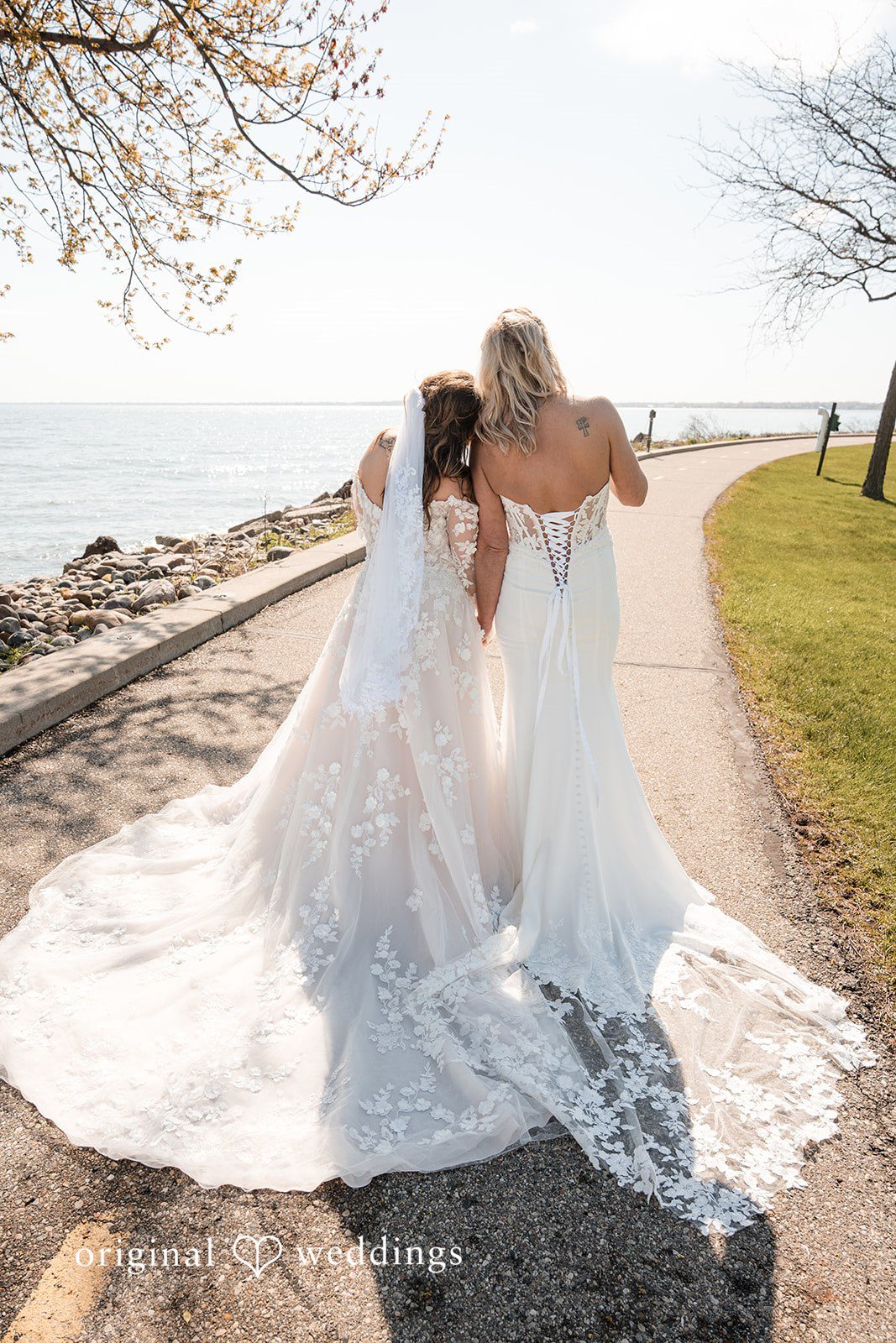 Bride and bride posing together with a sunset view behind them