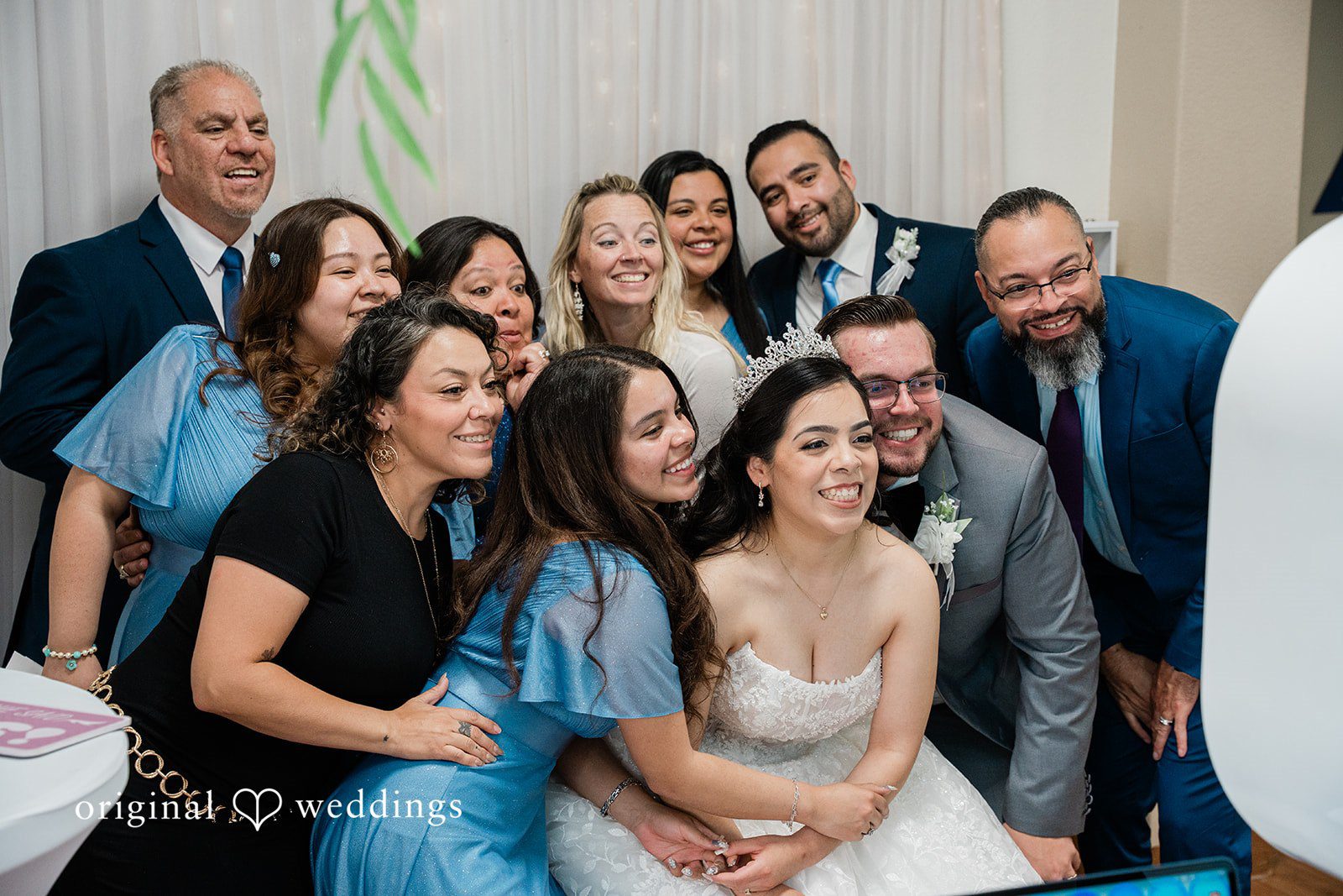 Bride and groom taking group photo with family and friends at Towngate Community Center