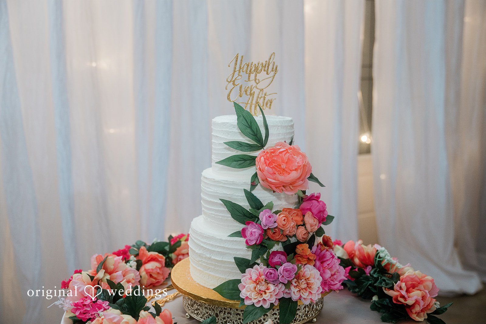 Hilary + Thomas An all-white wedding cake adorned with fresh florals