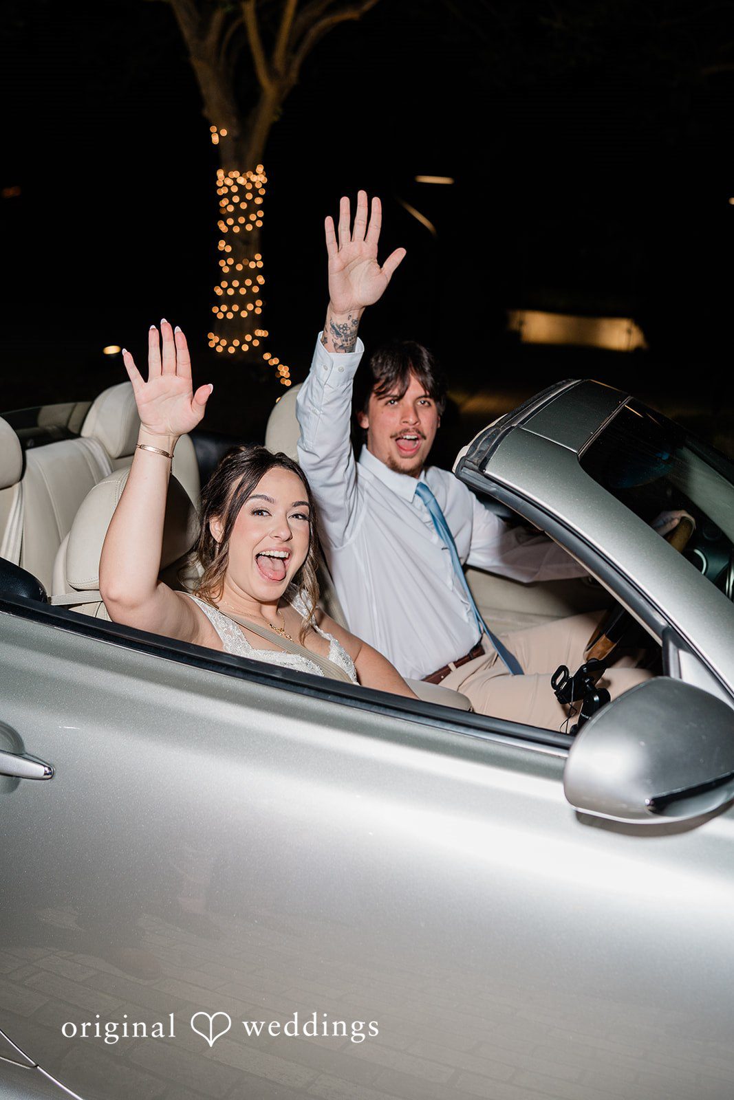 Candid wedding exit shot with couple waving hand