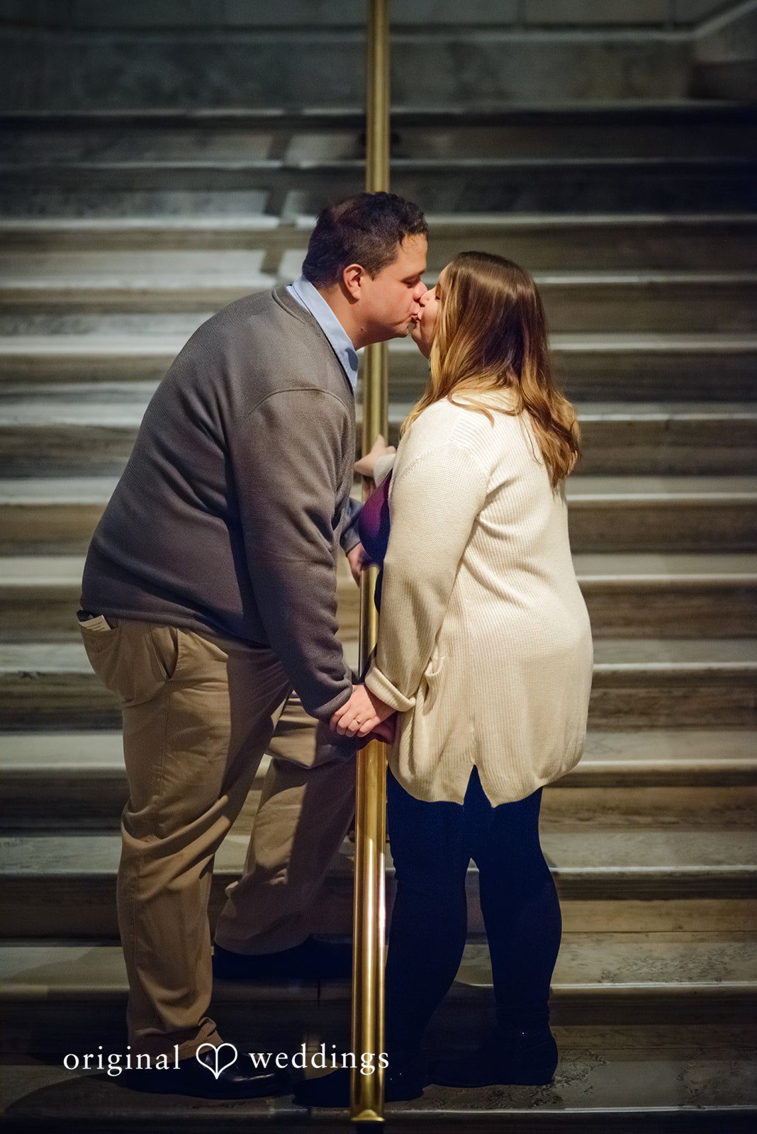 Nicole + Greg The couple shares a kiss by the stairs