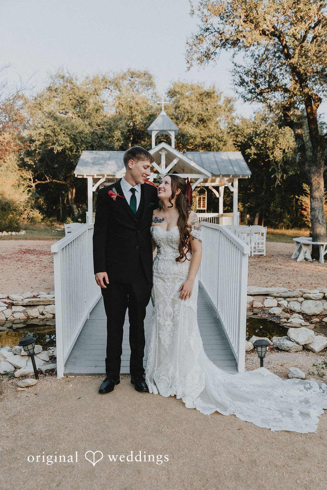 Bride and groom standing together on a white bridge