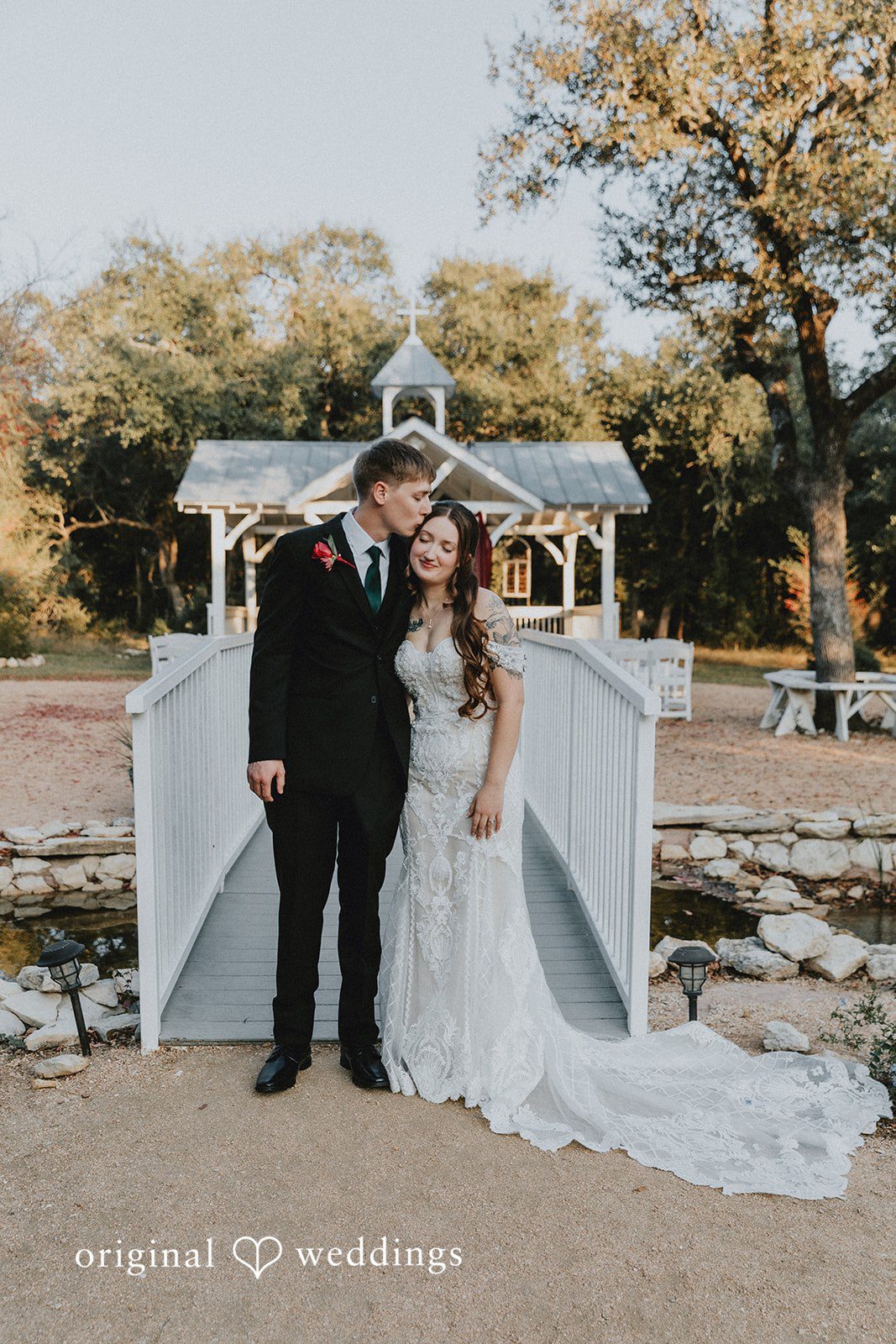 Groom kissing the bride on the forehead