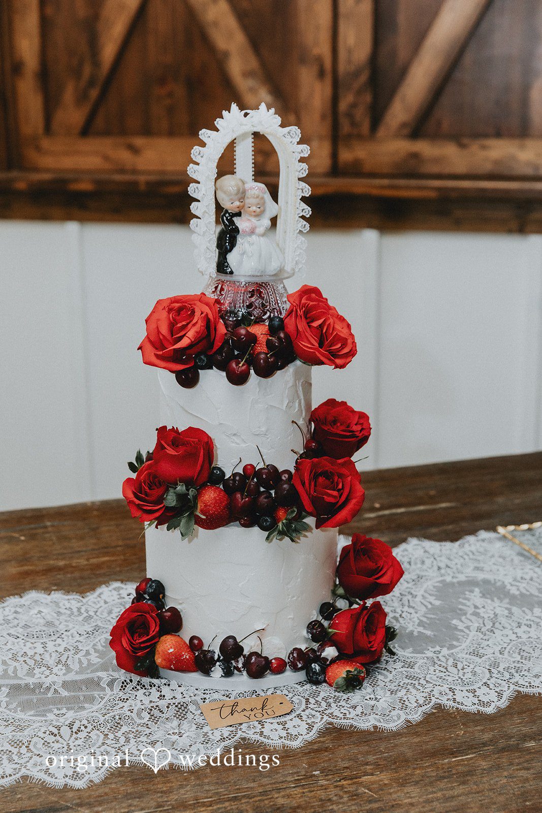 Elegant wedding cake with red roses and fresh fruit at Western Sky wedding venue