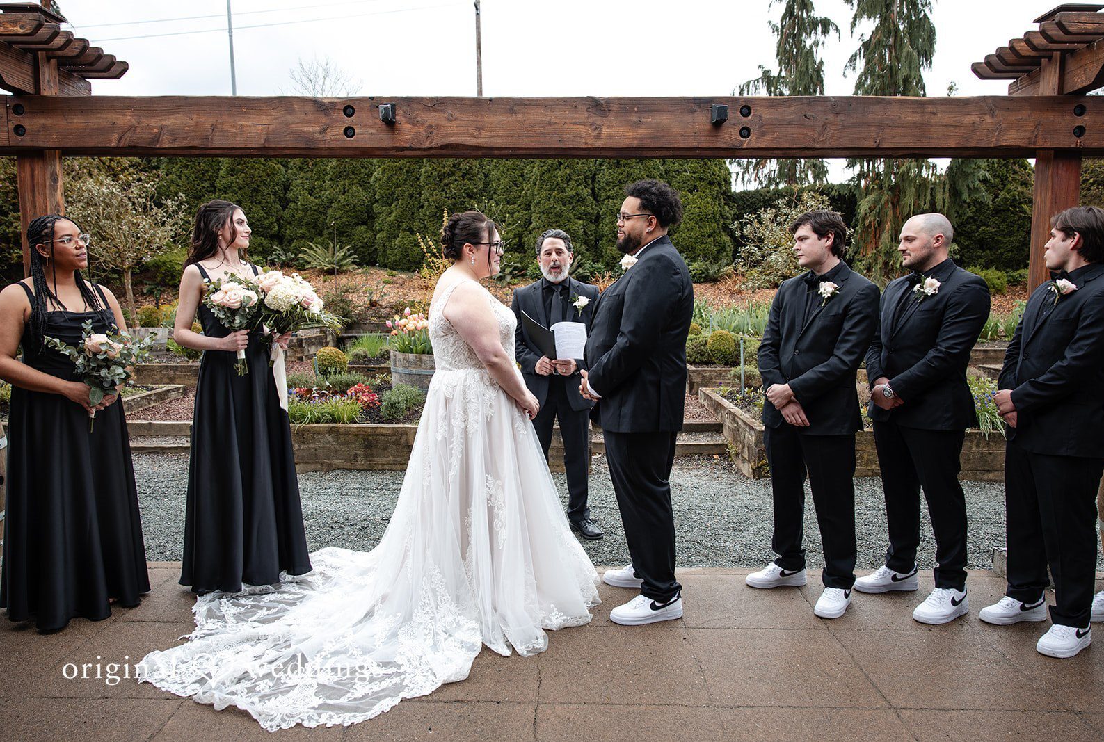 Seattle wedding photographers from Original Weddings capturing bride and groom standing in front of priest looking at each other at Willows Lodge