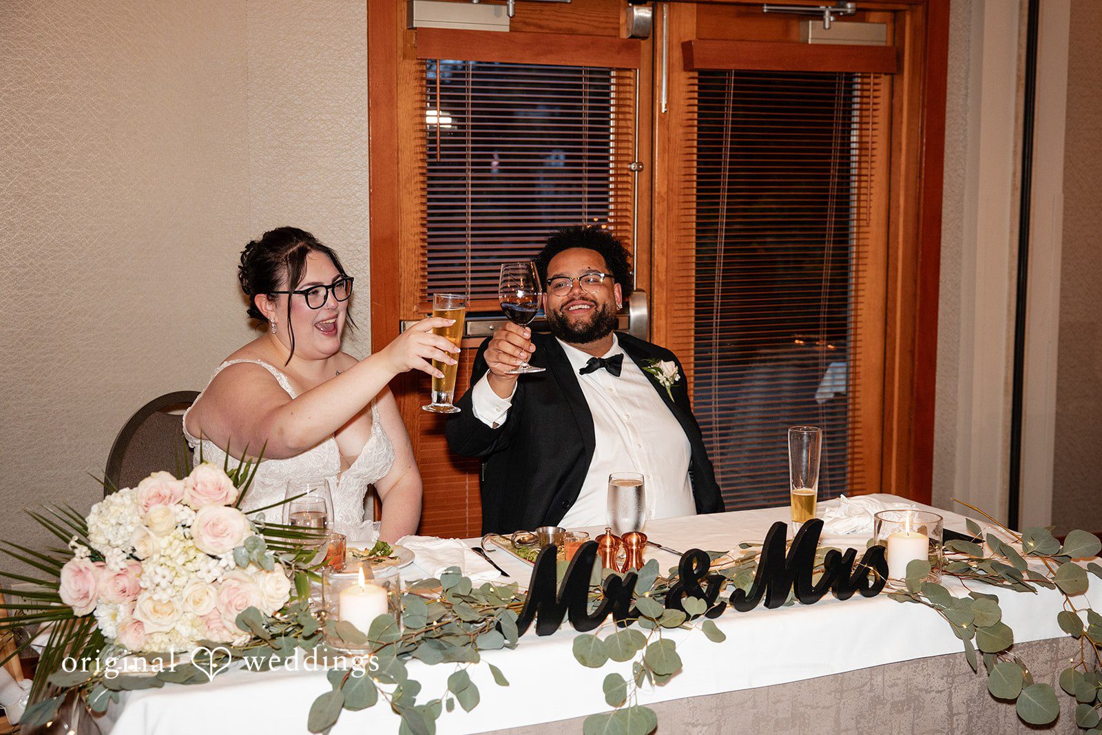 Seattle Wedding Photographers capturing bride and groom seated at reception table at Willows Lodge by Original Weddings