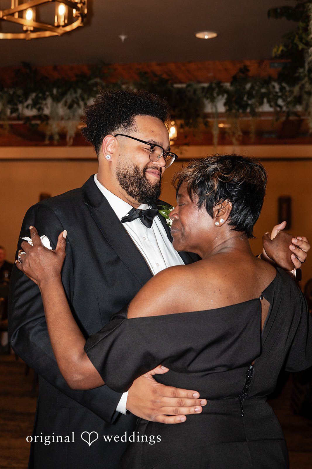 Joyful groom dance floor moment with someone during wedding reception