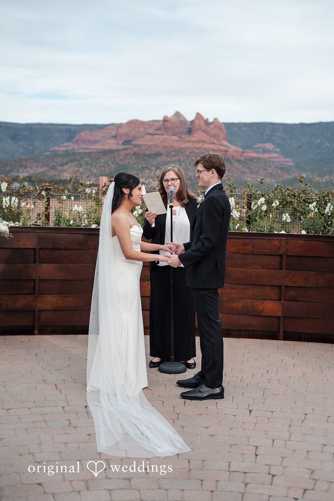 Romantic eye contact between bride and groom while holding hands