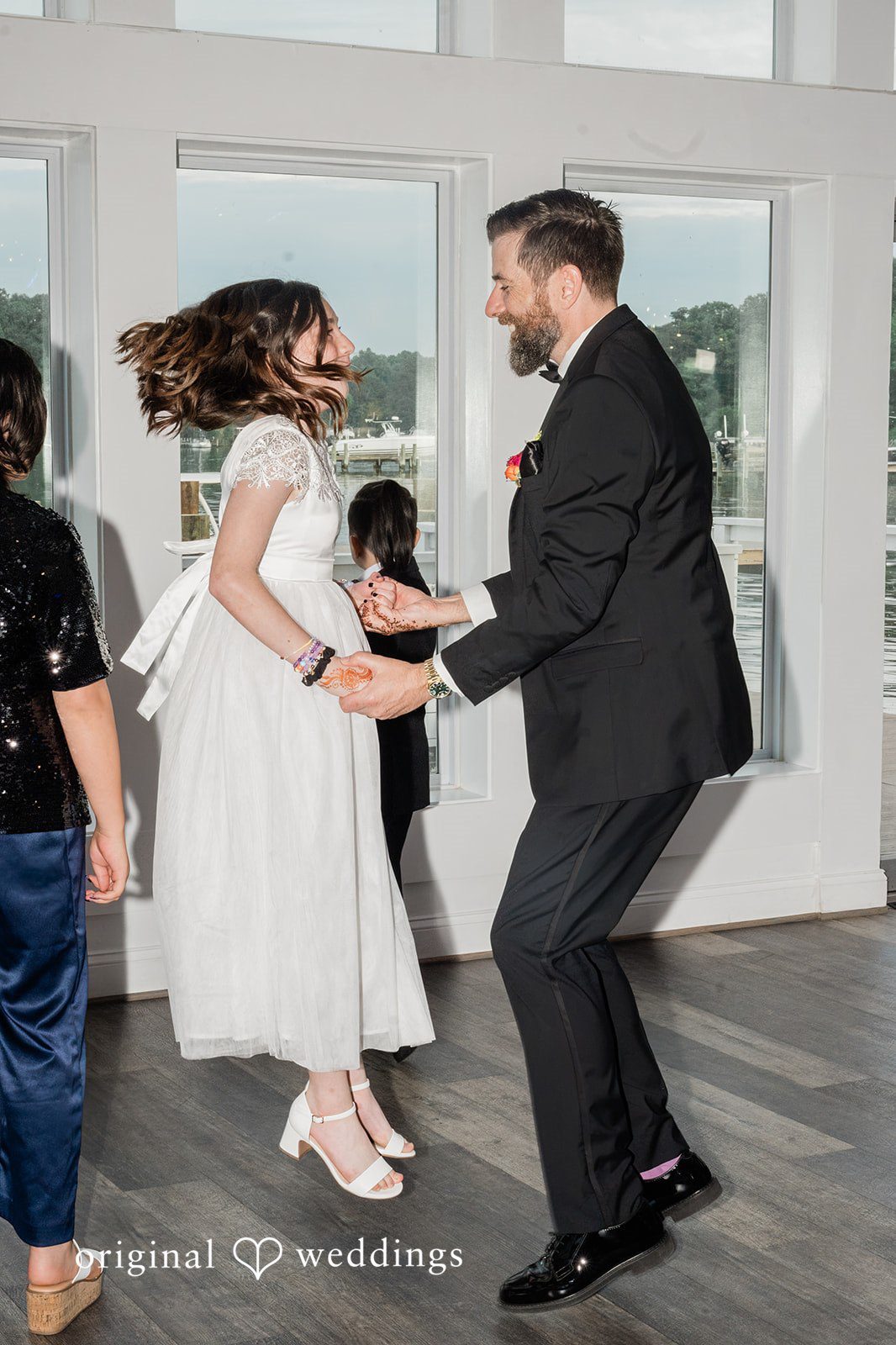 Groom sharing a joyful dance with a young girl