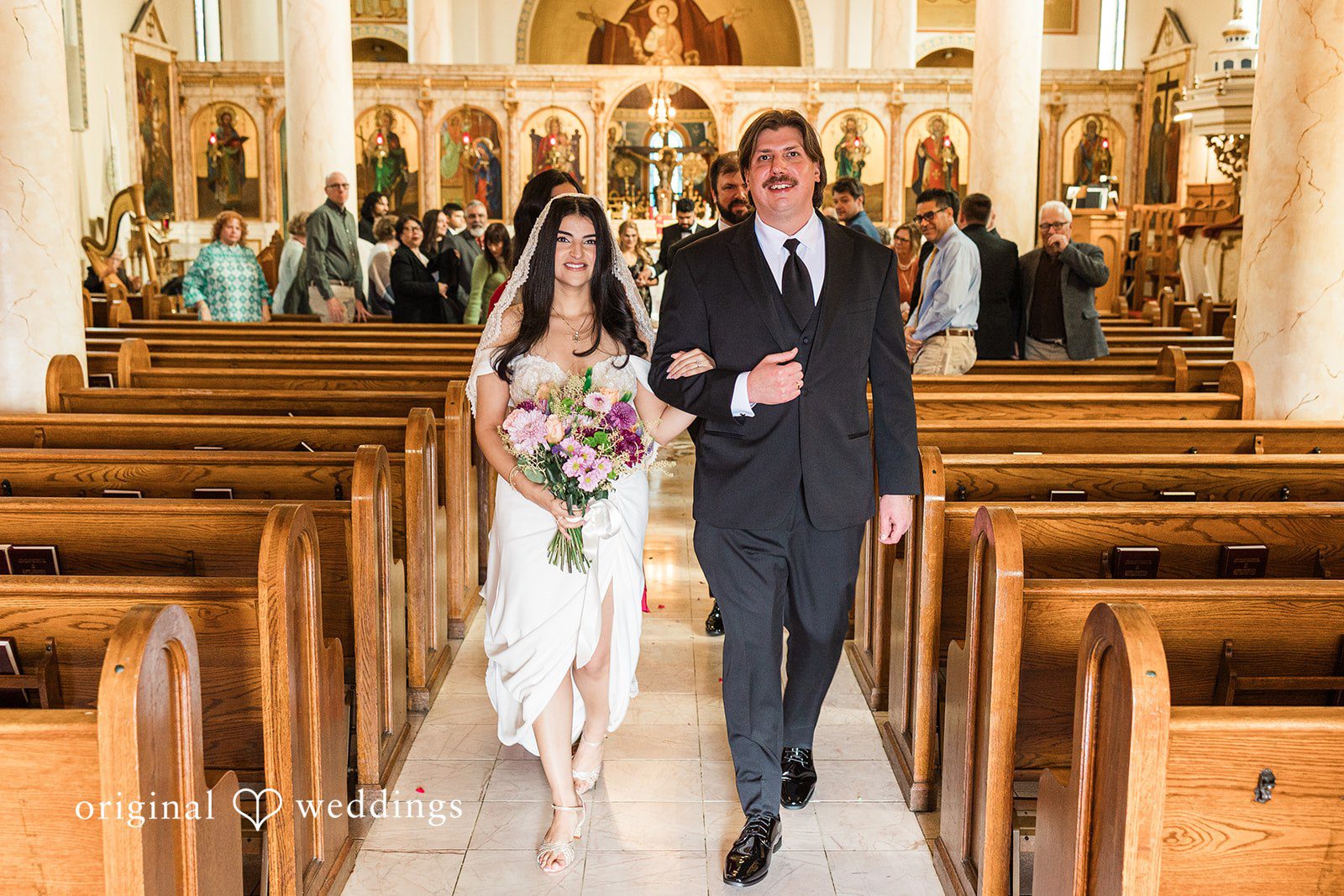 Zaina + Nick Cleveland Wedding Photographers capturing couple walking outside at Annunciation Greek Orthodox Church by Original Weddings