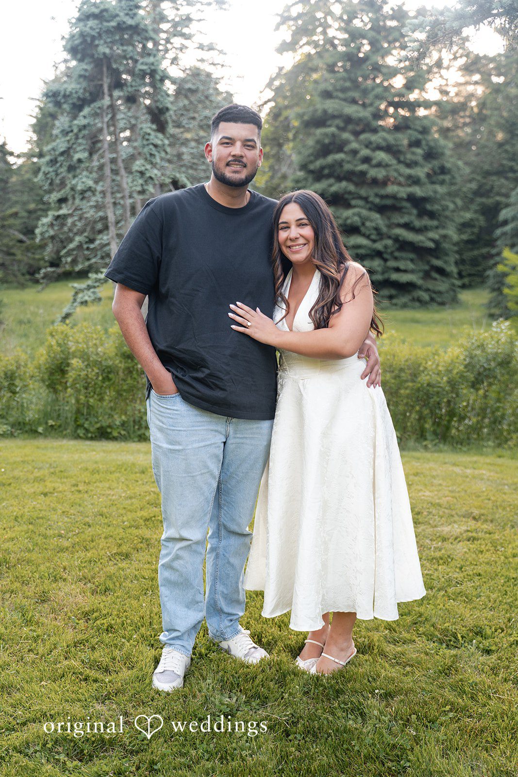 Anya + Max Couple poses together with warm smiles in a scenic garden setting