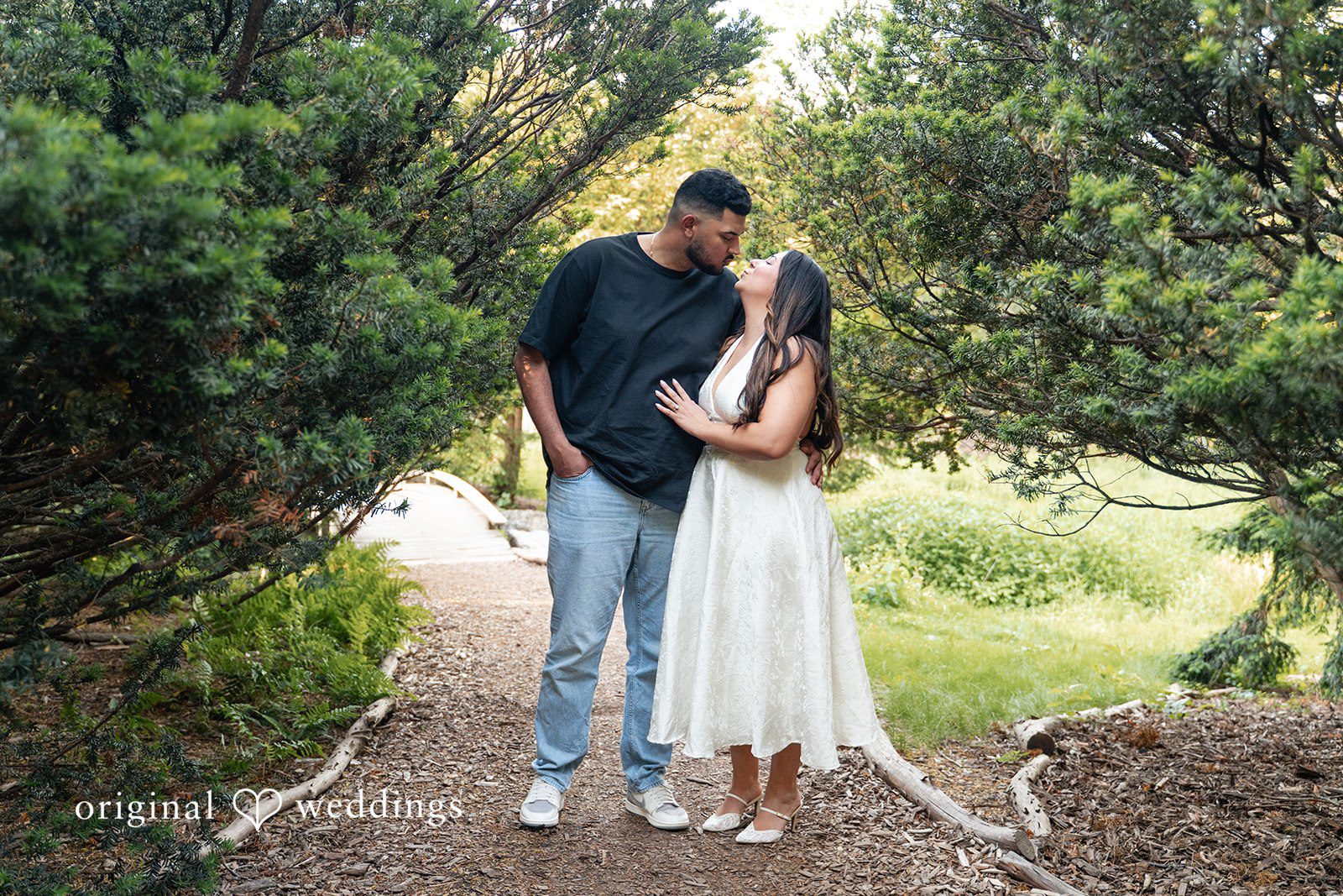 Anya + Max The couple shares a romantic moment beneath lush greenery during their engagement session at Arnold Arboretum