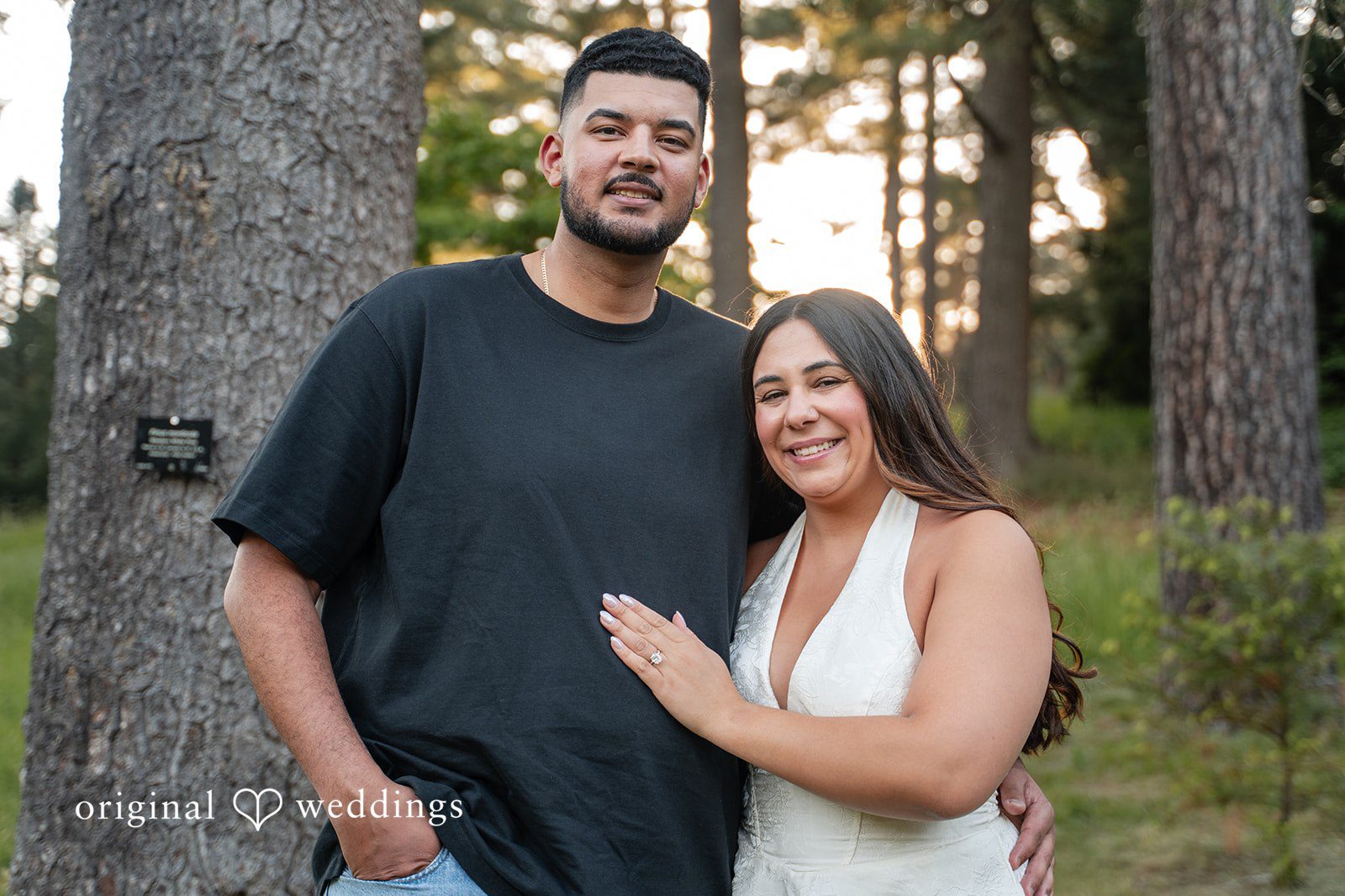 Anya + Max The couple smiles warmly for a portrait among the trees