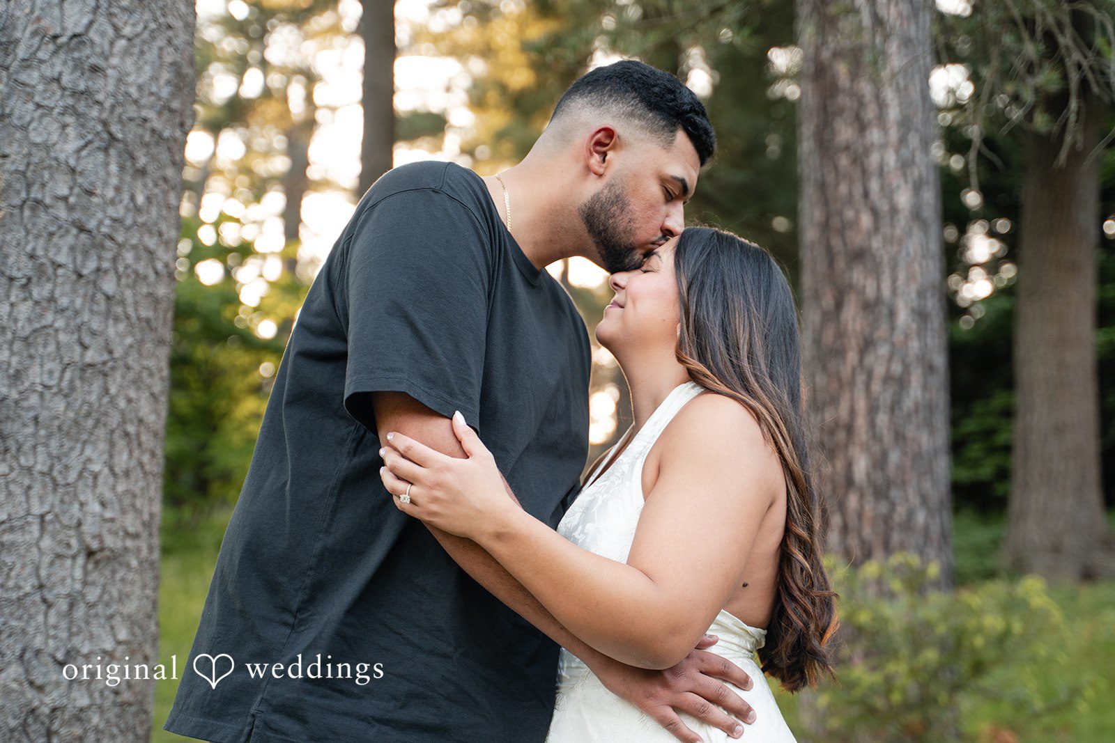 Anya + Max Couple shares a sweet forehead kiss among the trees