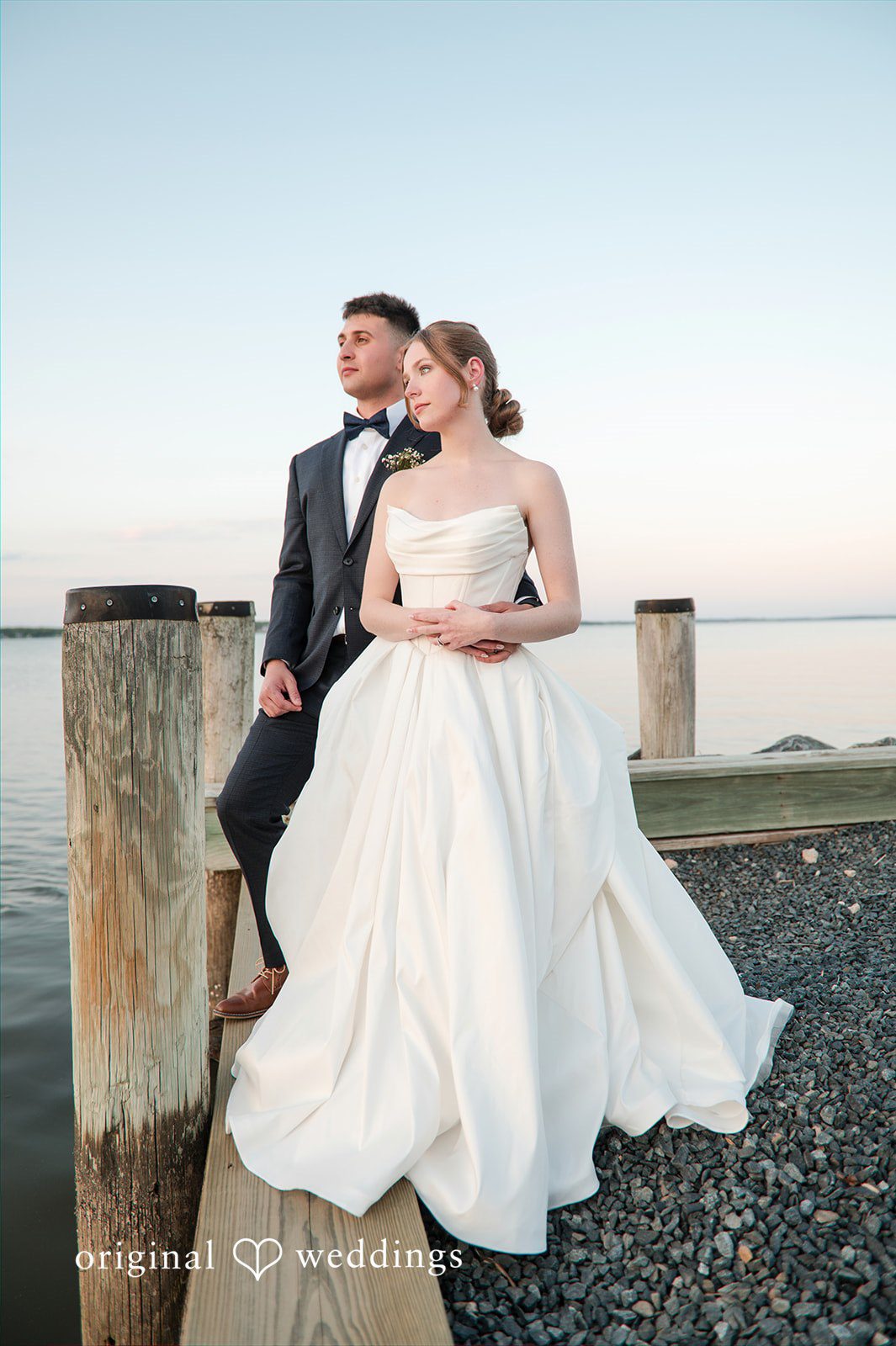 Andrew + Paige Bride and groom watching the water from the end of the dock