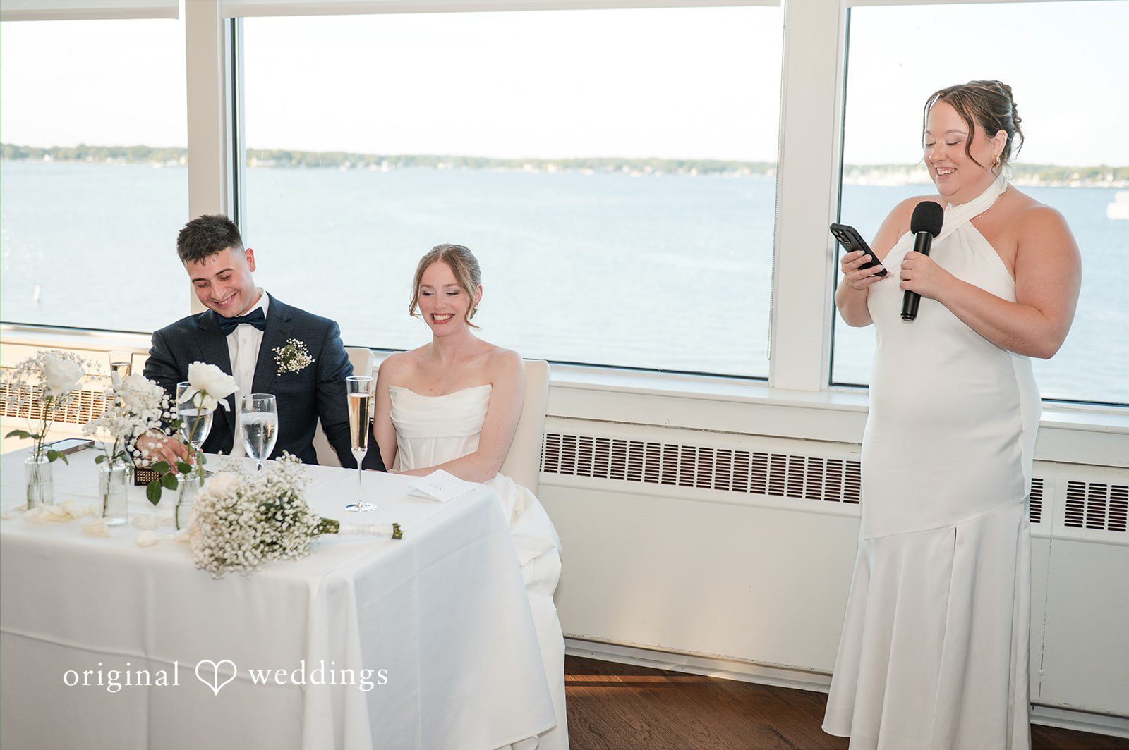 Andrew + Paige Newlyweds listening to speeches at their reception table