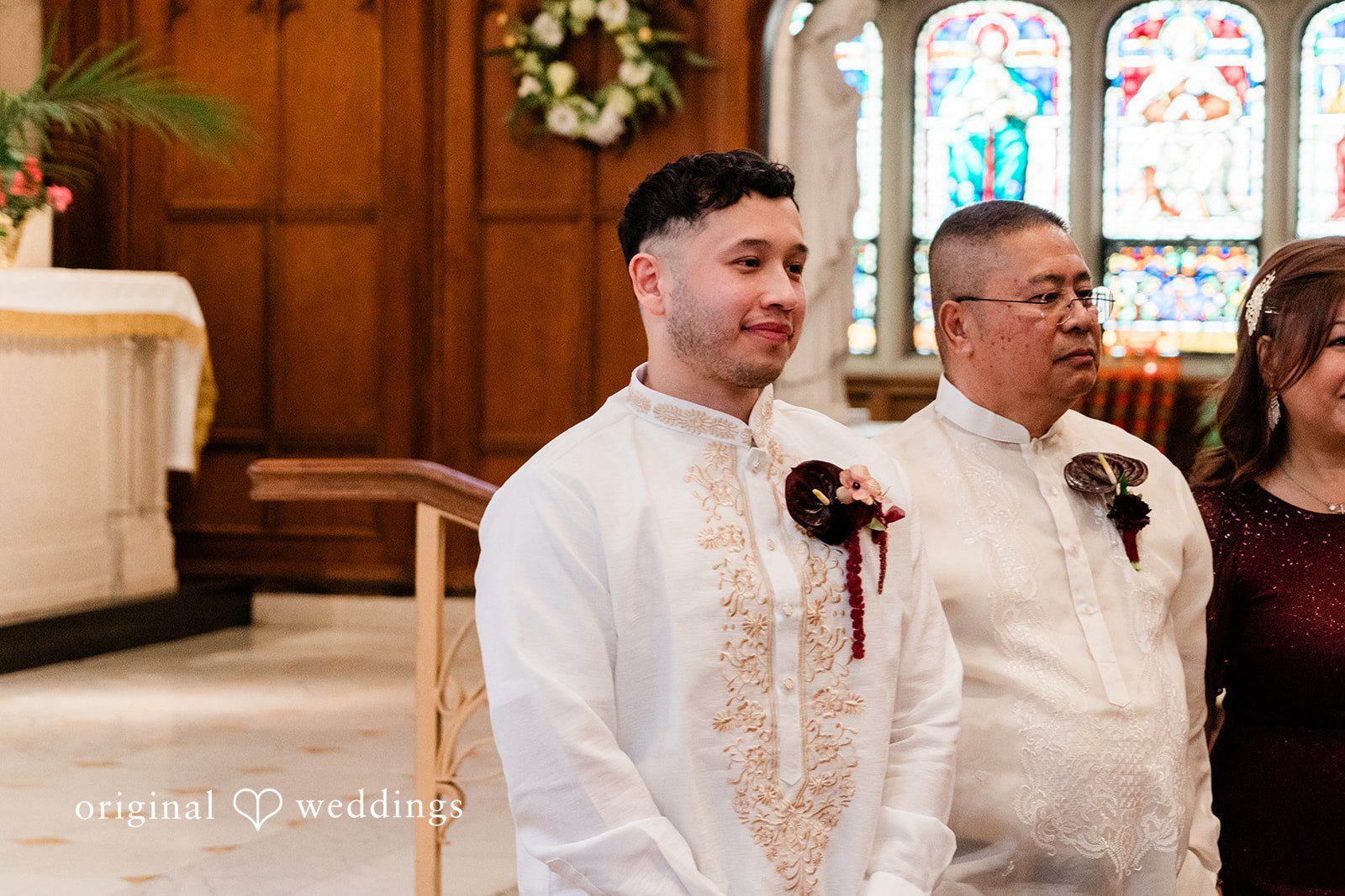 Michael + Maria Groom standing with family during the church ceremony in traditional embroidered attire.