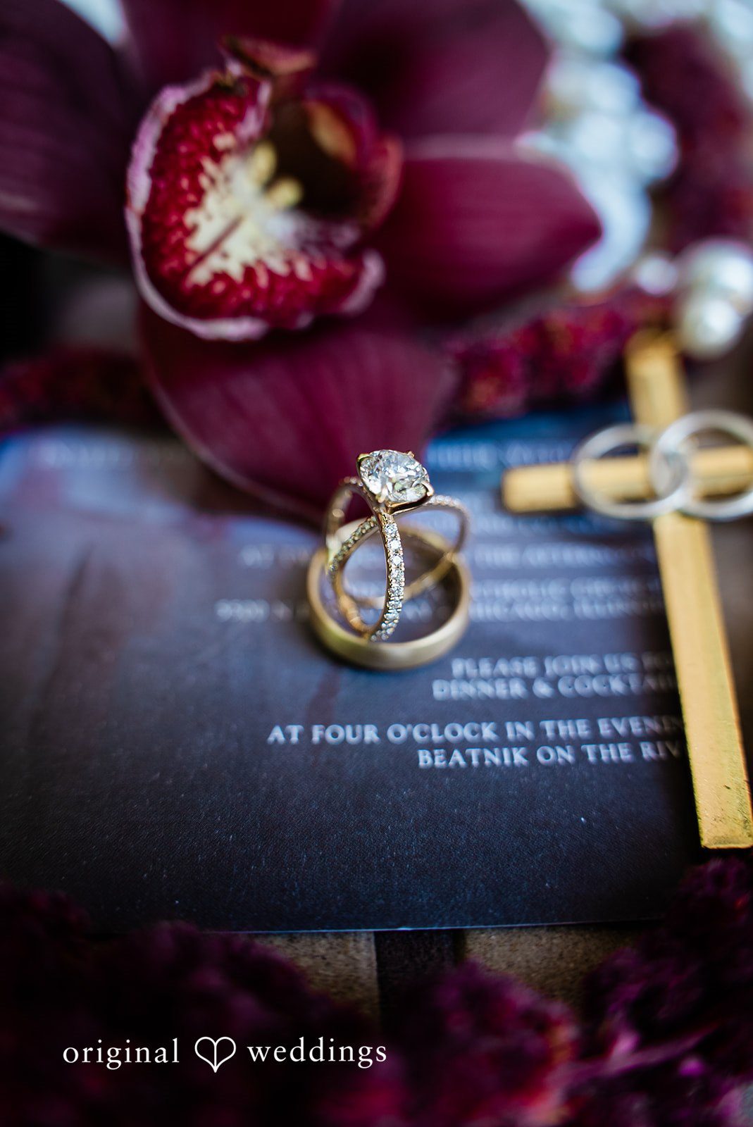 Michael + Maria Close-up of the wedding rings resting on the invitation suite with rich floral details
