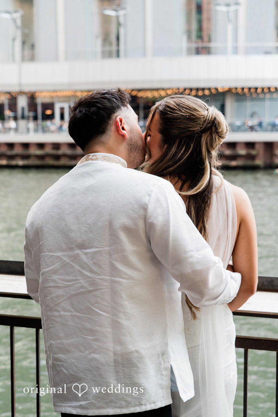 Michael + Maria Bride and groom sharing a romantic kiss by the river at Beatnik on the River.